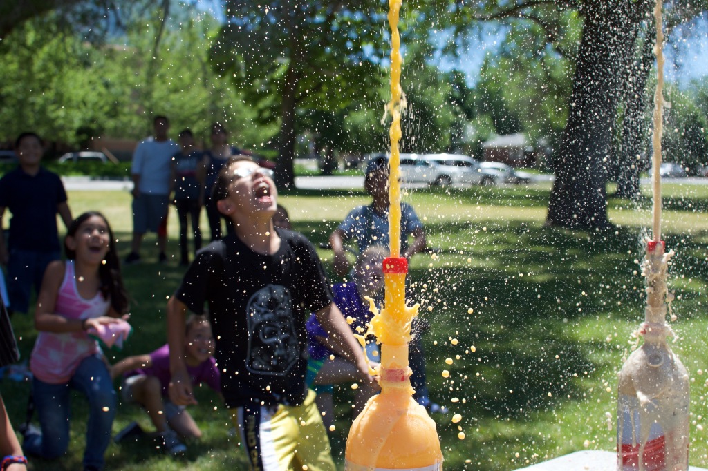 Fans rush the stage as fountains of soda erupt.